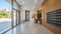 Portal de un edificio reformado con suelo, iluminación y buzones nuevos